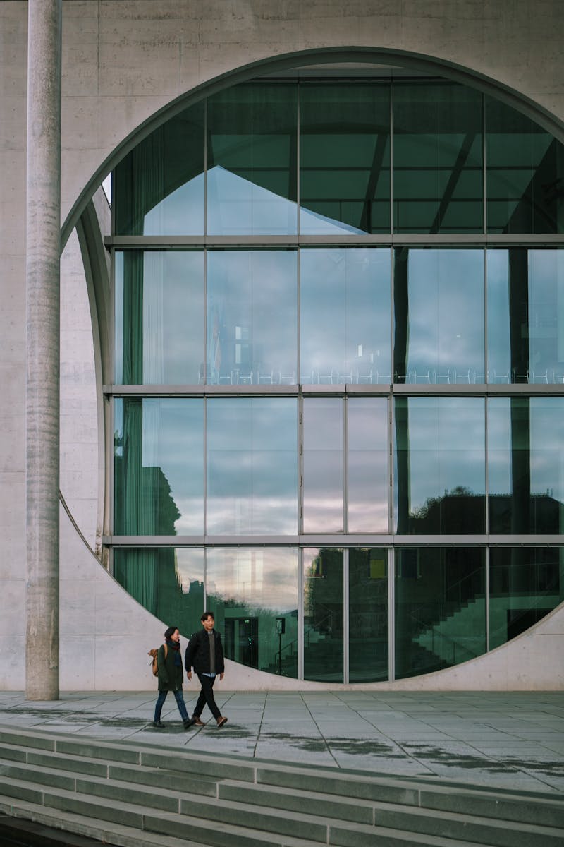 People walking by the Marie-Elisabeth-Lüders-Haus in Berlin with its striking modern architecture.