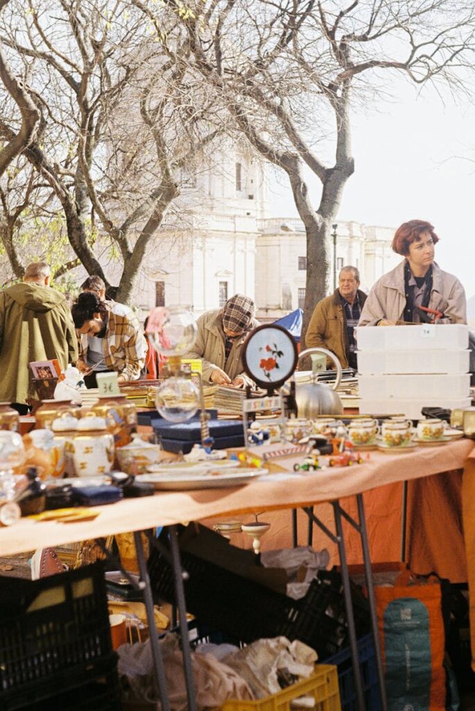 Discover antiques and treasures at an outdoor flea market in Lisbon surrounded by autumn trees.