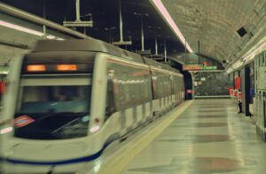High-speed train departing a dimly lit subway station in Madrid at night, showcasing urban transit.