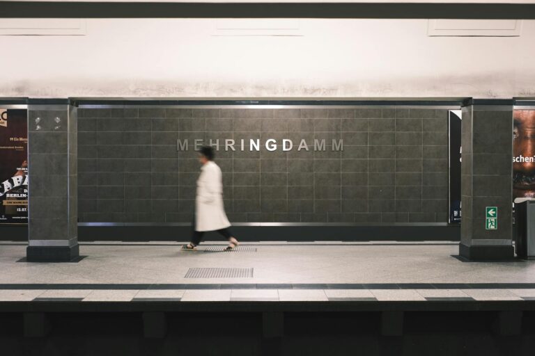 A blurred motion shot of a person walking at Mehringdamm subway station in Berlin, Germany.