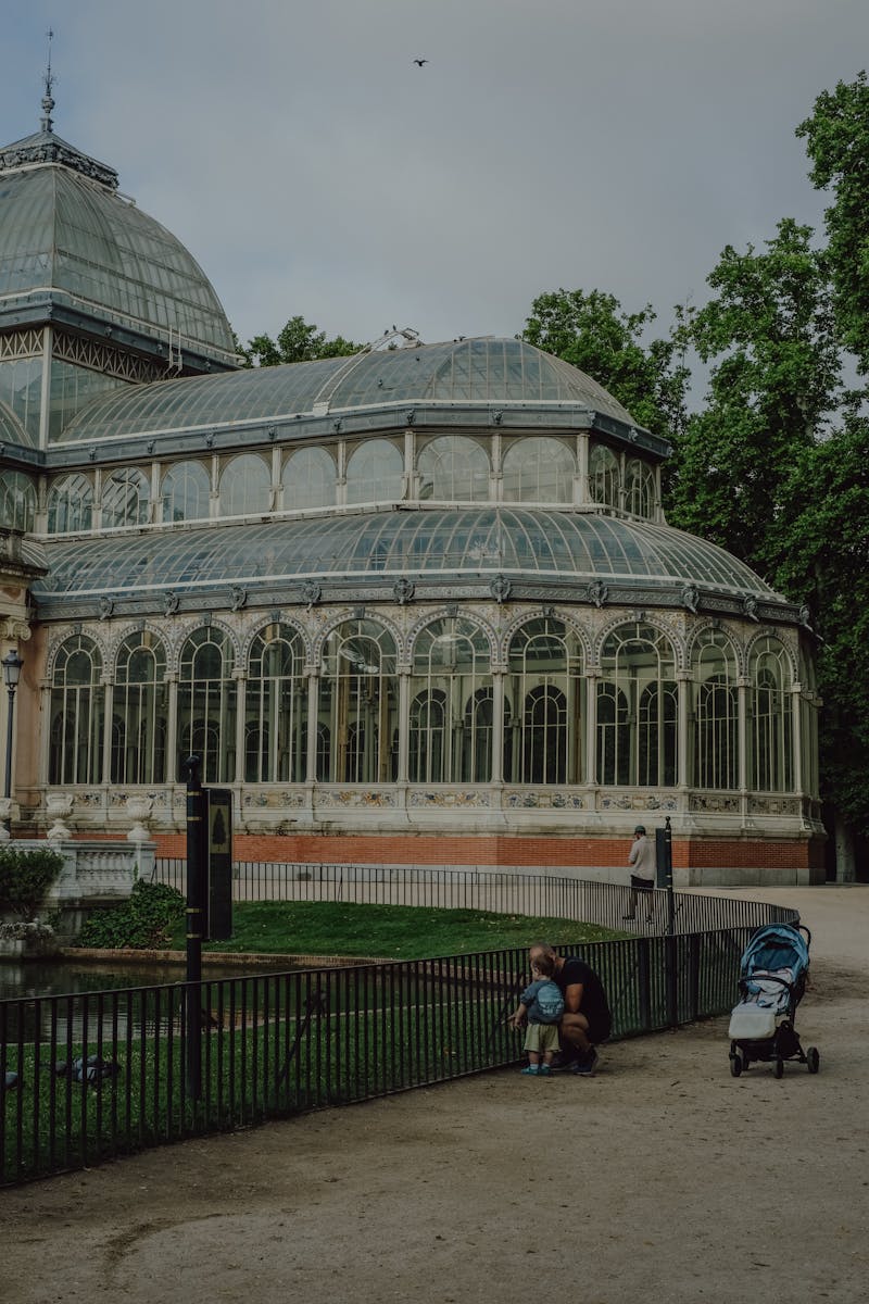 Family enjoying a day out near the iconic Palacio de Cristal in Madrid, Spain.