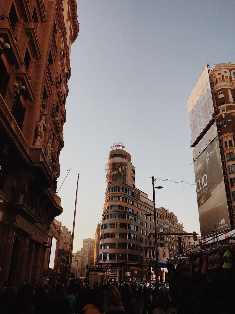 A bustling scene of Madrid's Calle Gran Vía with the prominent Edificio Capitol at dusk, capturing the city's vibrant energy.