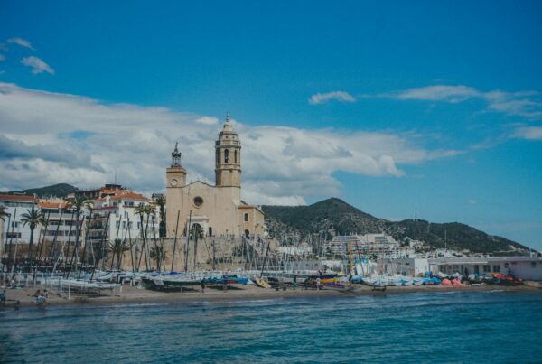 a large building sitting on top of a beach next to a body of water