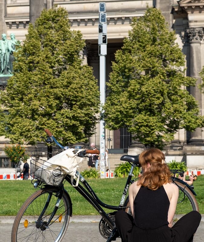 a woman sitting on the ground next to a bike