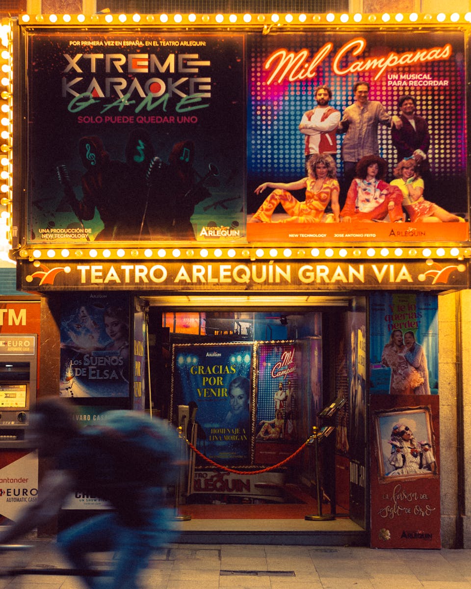 Capture the lively atmosphere outside Teatro Arlequín Gran Via, Madrid at night.