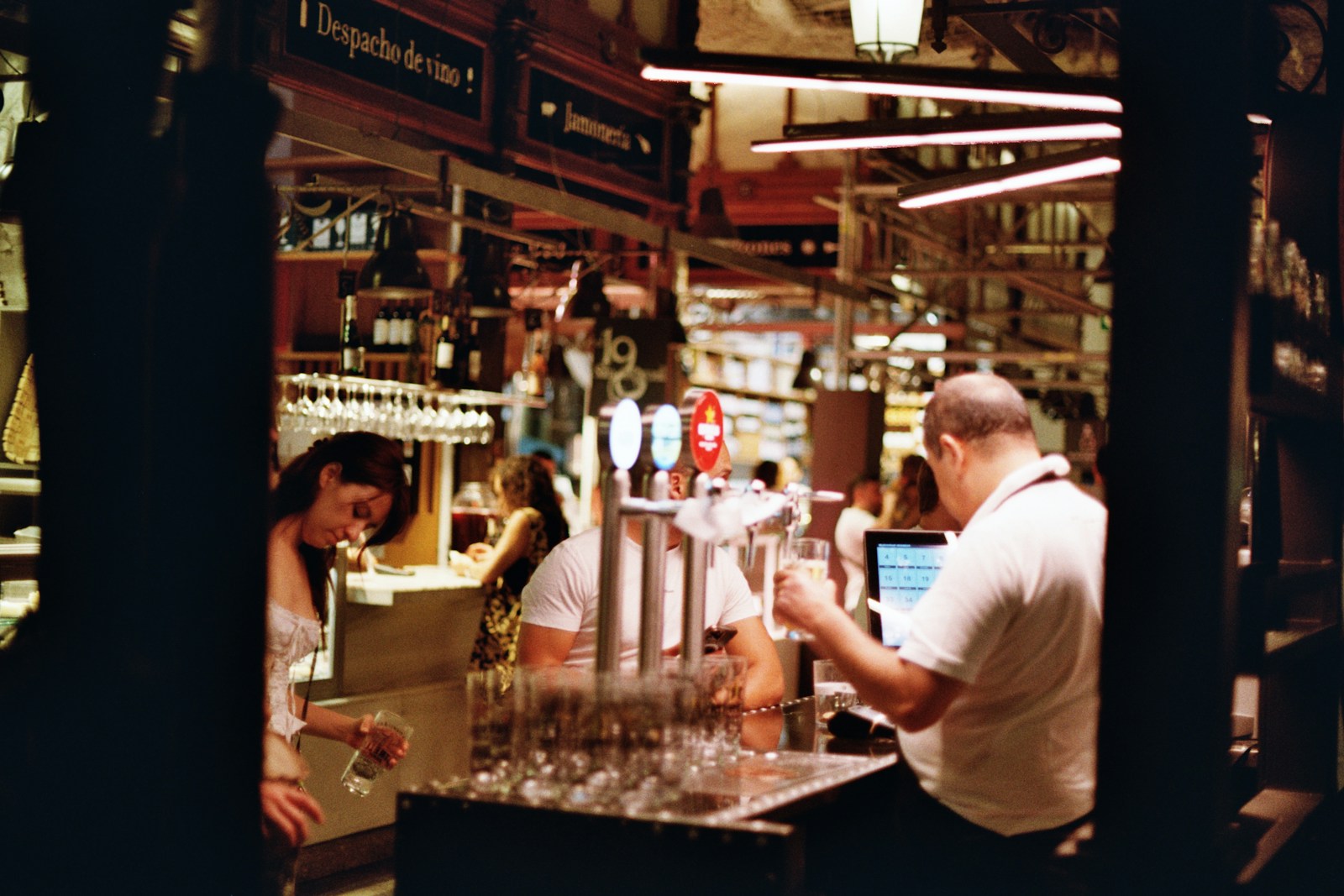 A man pouring a glass of wine at a bar