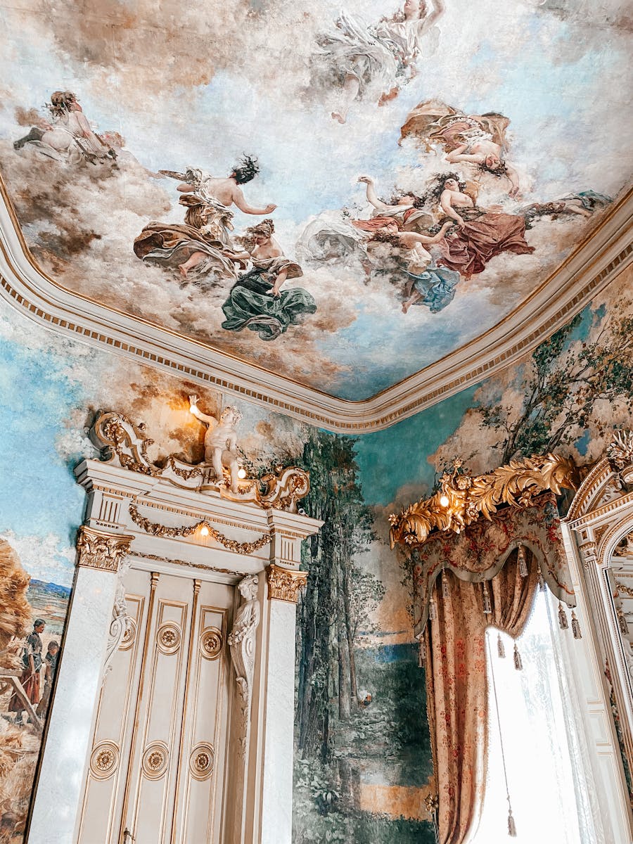 Intricate baroque frescoes adorn the ceiling of a grand palace room in Madrid, Spain.