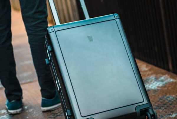 a person pulling a rolling suitcase on a sidewalk